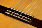 The bridge, tie-block and saddle of a 1999 Jose Marin Plazuelo flamenco guitar made of spruce and cypress